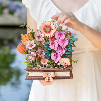 Wooden Blooming Book flower arrangement being adjusted by hand