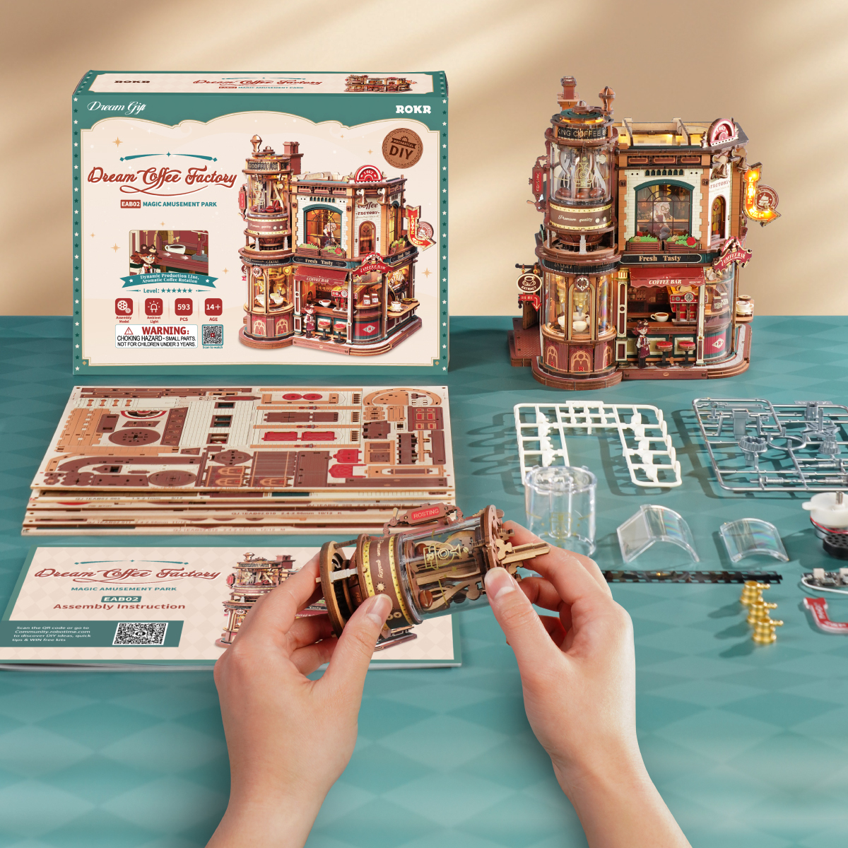 Dream Coffee Factory assembly scene with instructions, wooden sheets, and completed model