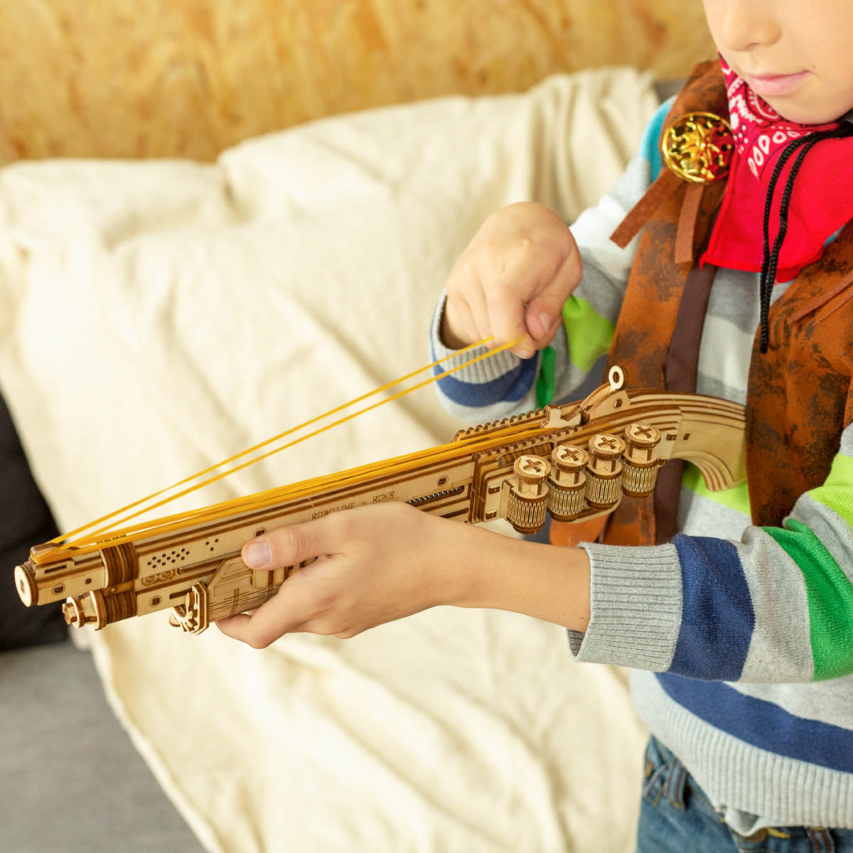 ROKR gun model set with child holding the larger wooden gun