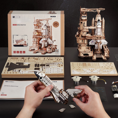 Space Shuttle assembly scene with package, instructions, and wooden parts